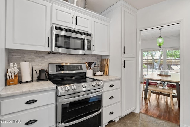 710 E Hayward Ave, Phoenix, AZ 85020 - kitchen with appliances with stainless steel finishes, white cabinetry, tasteful backsplash, and ornamental molding
