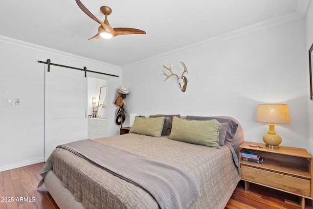 710 E Hayward Ave, Phoenix, AZ 85020 - bedroom featuring a barn door, crown molding, wood finished floors, baseboards, and ensuite bathroom
