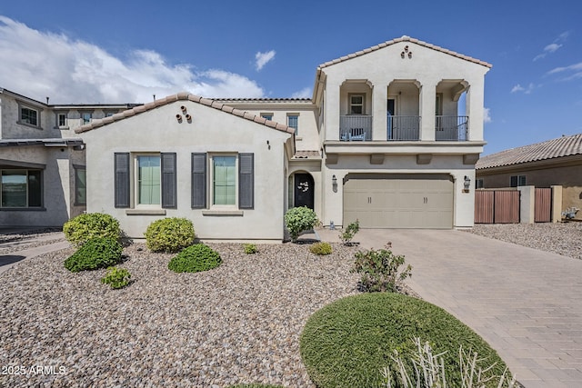 22960 N 94th Ln, Peoria, AZ 85383 - mediterranean / spanish home with a balcony, stucco siding, a tile roof, a garage, and decorative driveway