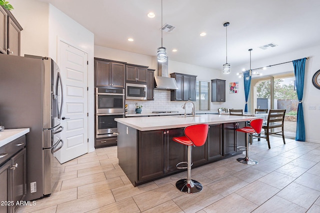 22960 N 94th Ln, Peoria, AZ 85383 - kitchen featuring appliances with stainless steel finishes, wall chimney range hood, a sink, light countertops, and backsplash