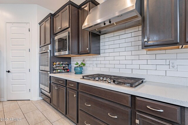 22960 N 94th Ln, Peoria, AZ 85383 - kitchen featuring extractor fan, appliances with stainless steel finishes, dark brown cabinetry, and backsplash