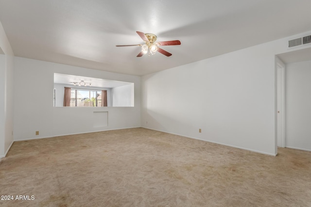 empty room with light carpet and ceiling fan with notable chandelier