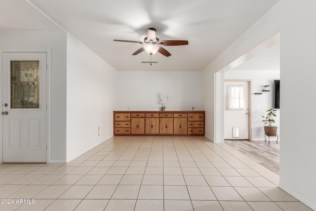 tiled empty room with ceiling fan