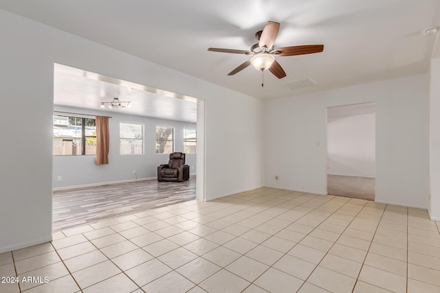 tiled spare room with ceiling fan