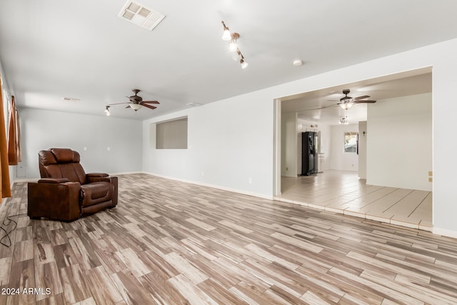 living area with ceiling fan and light hardwood / wood-style flooring