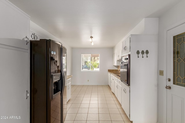 kitchen with white cabinets, black fridge with ice dispenser, and light tile patterned floors