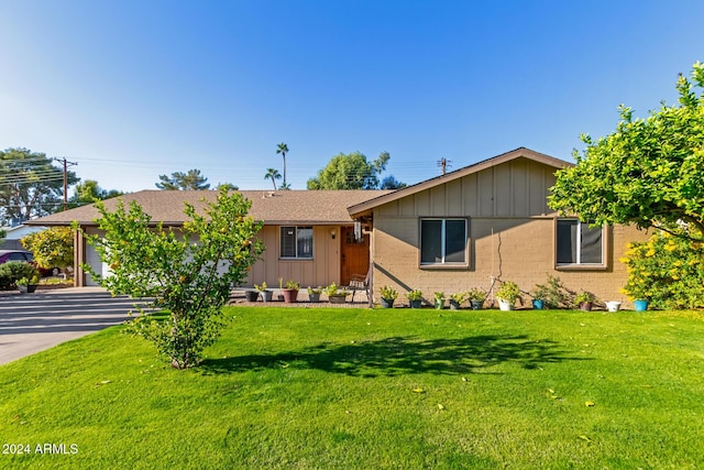 ranch-style house featuring a garage and a front lawn