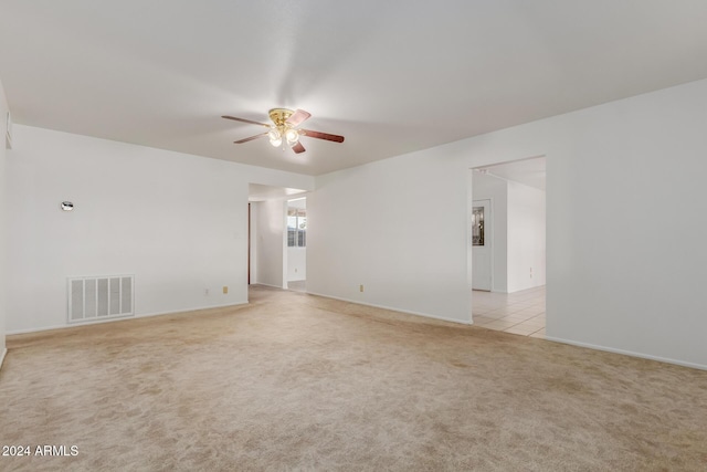 empty room featuring ceiling fan and light carpet