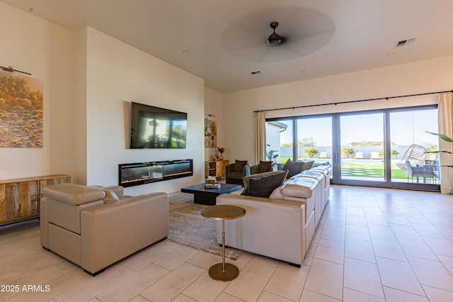 10918 W Dove Roost Rd, Queen Creek, AZ 85144 - living room with a ceiling fan, light tile patterned flooring, and a glass covered fireplace