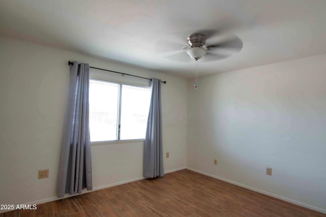 spare room featuring baseboards, ceiling fan, and wood finished floors