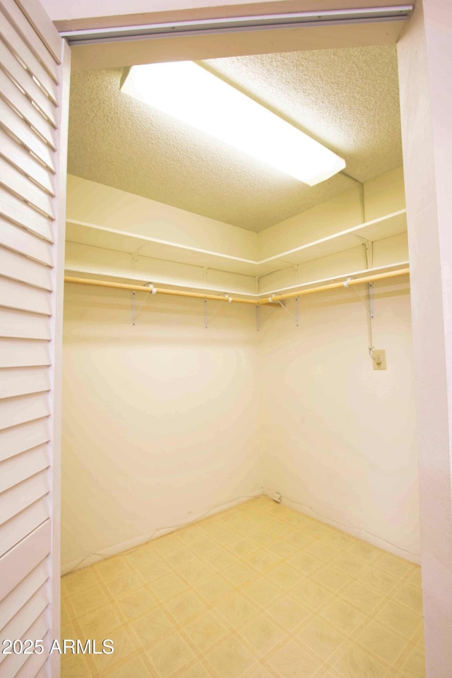 walk in closet with light floors