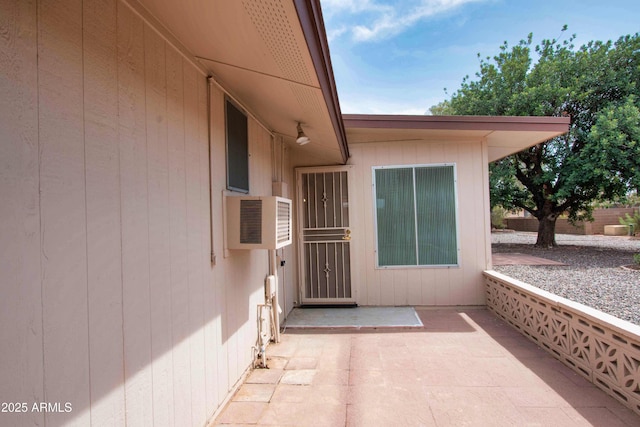 view of exterior entry featuring cooling unit and a patio area
