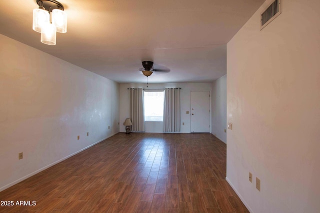 empty room featuring baseboards, visible vents, wood finished floors, and a ceiling fan
