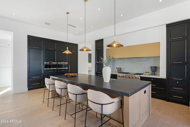 kitchen featuring a large island, light wood-style flooring, and a kitchen breakfast bar