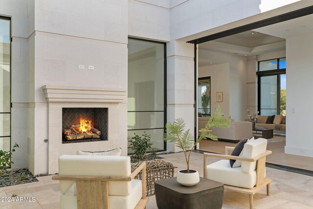 view of patio with an outdoor living space with a fireplace