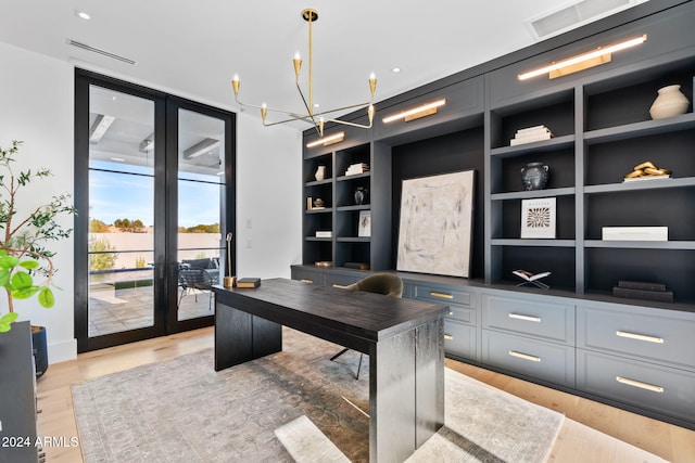 office space with visible vents, built in shelves, light wood-style flooring, french doors, and a chandelier