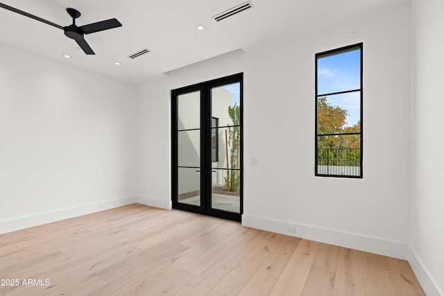 spare room with visible vents, baseboards, ceiling fan, and light wood finished floors