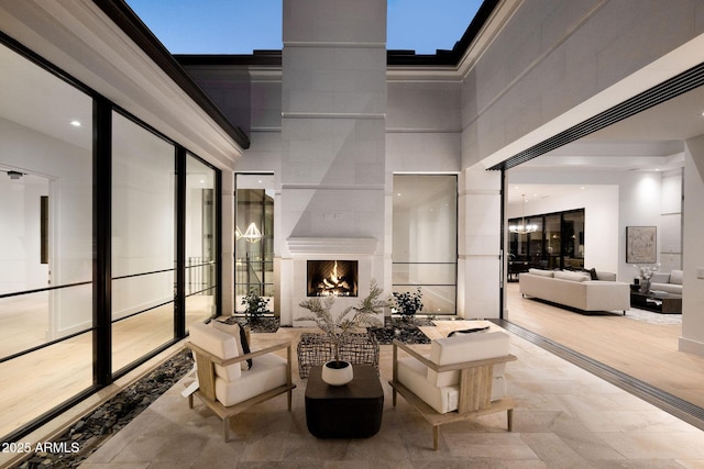 living area with a skylight, a high ceiling, and a premium fireplace