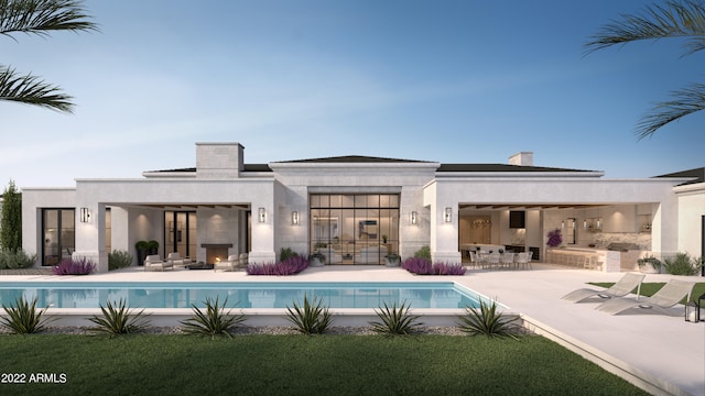 back of house featuring a patio area, an outdoor pool, and stucco siding