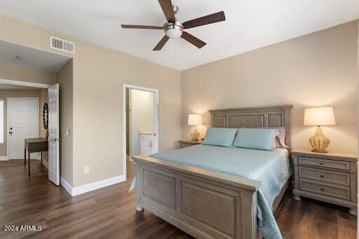 bedroom with ceiling fan, dark wood-type flooring, and ensuite bath