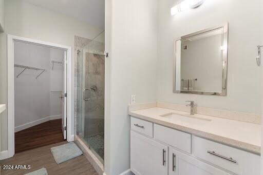 bathroom with vanity, wood-type flooring, and walk in shower