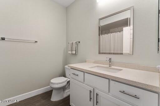 bathroom with hardwood / wood-style flooring, toilet, and vanity