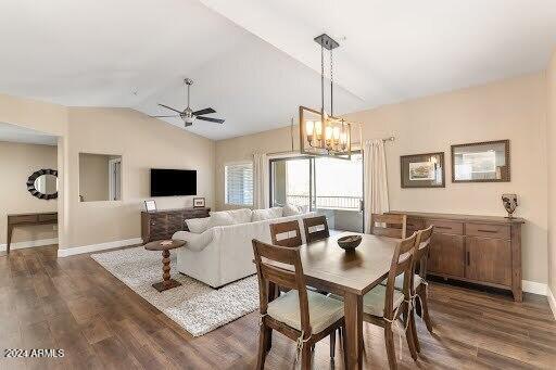 dining area with lofted ceiling, dark wood-type flooring, and ceiling fan with notable chandelier