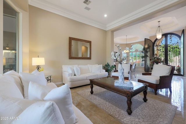 tiled living room featuring an inviting chandelier and crown molding