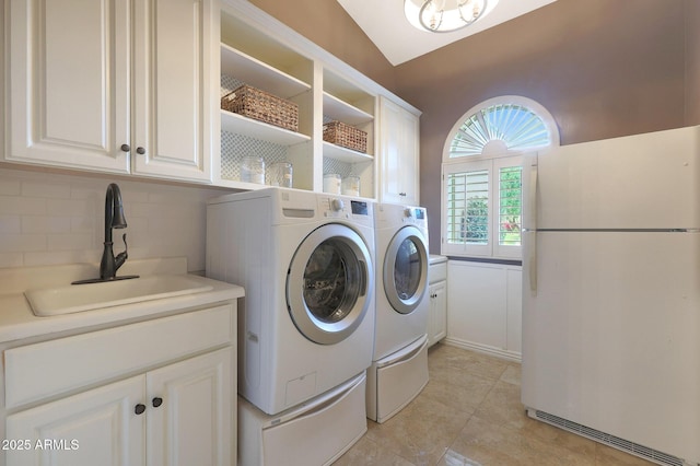 laundry area with washing machine and clothes dryer, sink, and cabinets