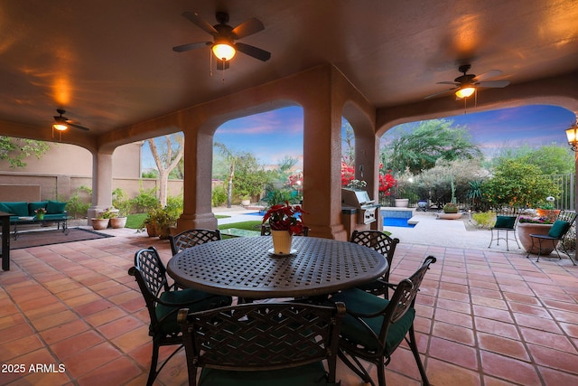 patio terrace at dusk with ceiling fan and a grill