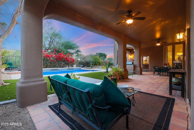 patio terrace at dusk featuring outdoor lounge area and ceiling fan