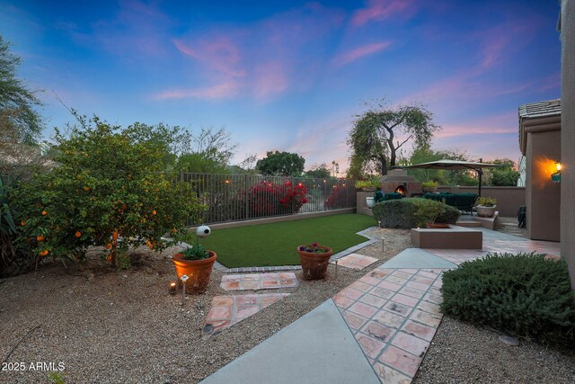 yard at dusk featuring a gazebo and a patio