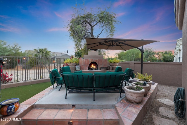 patio terrace at dusk with an outdoor living space with a fireplace