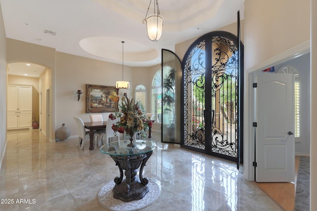 foyer entrance featuring french doors and a raised ceiling