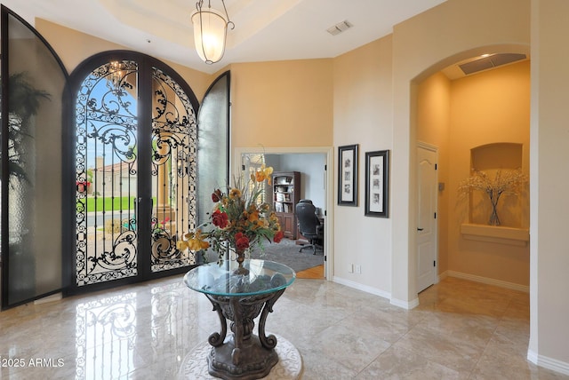 entrance foyer with a raised ceiling and french doors