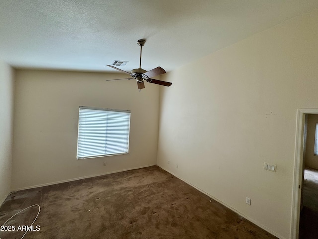 carpeted empty room featuring ceiling fan and a textured ceiling