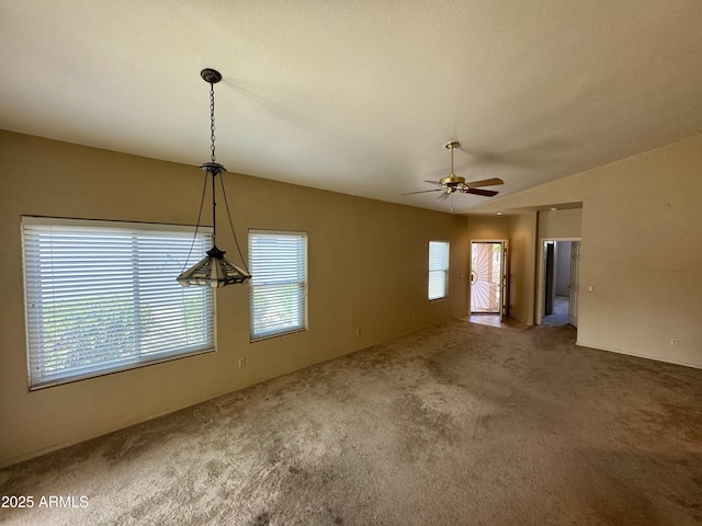 interior space with ceiling fan, lofted ceiling, and dark carpet