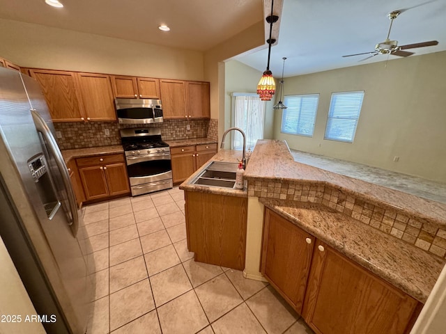 kitchen with sink, light tile patterned floors, pendant lighting, stainless steel appliances, and backsplash