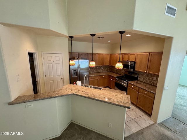 kitchen featuring sink, backsplash, hanging light fixtures, kitchen peninsula, and stainless steel appliances