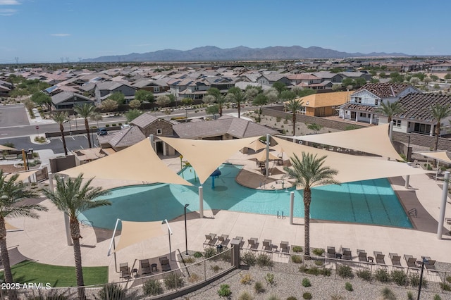 view of swimming pool with a mountain view, fence, and a residential view