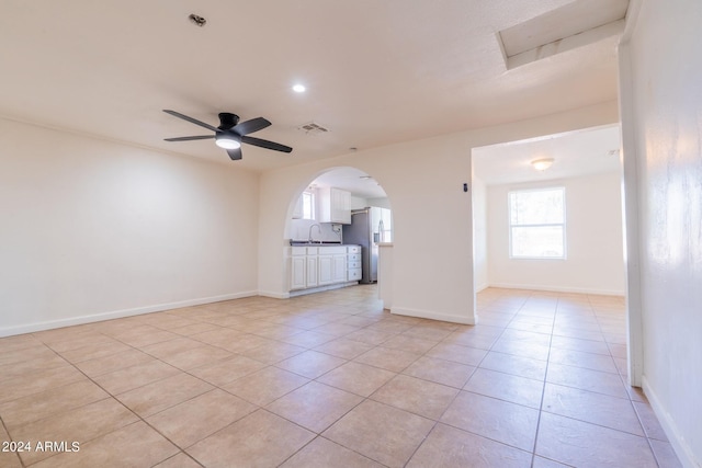 tiled empty room featuring ceiling fan and sink