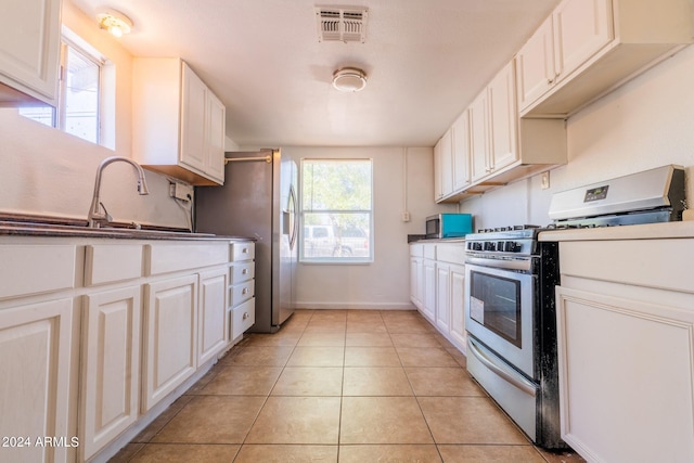 kitchen featuring white cabinets, light tile patterned flooring, sink, and appliances with stainless steel finishes