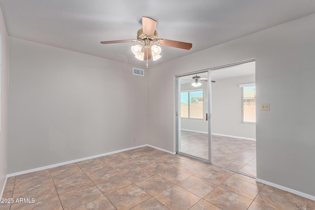 tiled spare room featuring ceiling fan