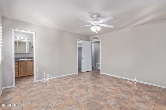 unfurnished bedroom with ceiling fan, a walk in closet, and connected bathroom