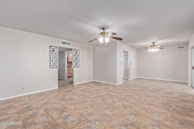 empty room featuring ceiling fan and a textured ceiling