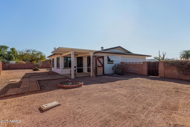 rear view of property featuring a pergola and a patio area