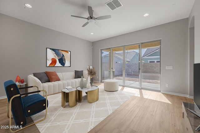 living room featuring ceiling fan and light hardwood / wood-style floors