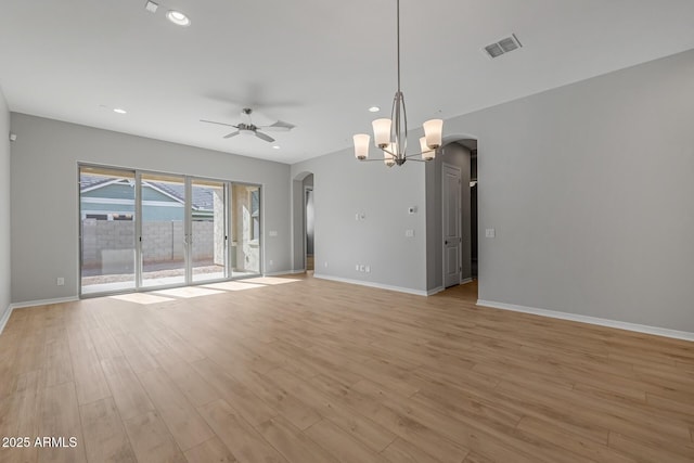 unfurnished living room featuring ceiling fan with notable chandelier and light hardwood / wood-style floors