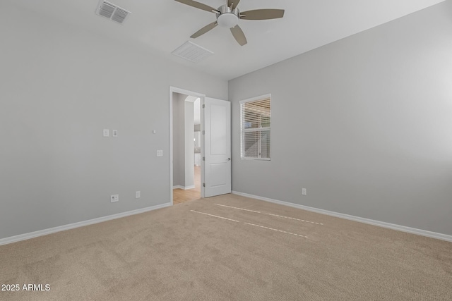 spare room with ceiling fan and light colored carpet