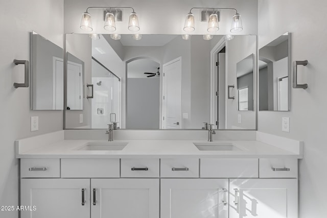 bathroom featuring vanity, ceiling fan, and a shower with shower door